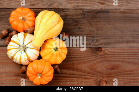 An autumn still life of decorative mini pumpkins, gourds and acorns on a rustic wood table. Horizontal format with copy space. Stock Photo