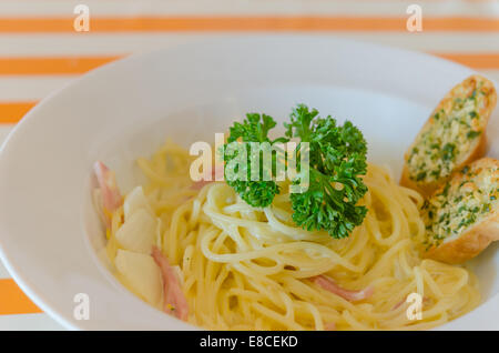 Spaghetti Carbonara with bacon and garlic bread on dish Stock Photo