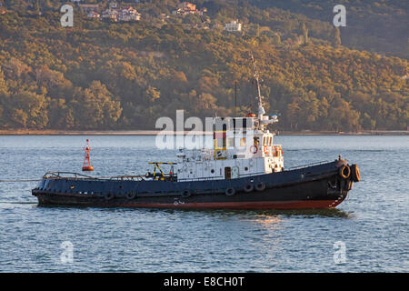 Black tug is underway on Black sea, Varna harbor, Bulgaria Stock Photo