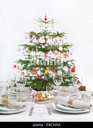 Festive table with Christmas tree in the background Stock Photo