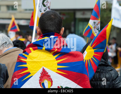 An exile Tibetan is showing his nation's colours at a protest rally in Bern, Switzerland. Stock Photo