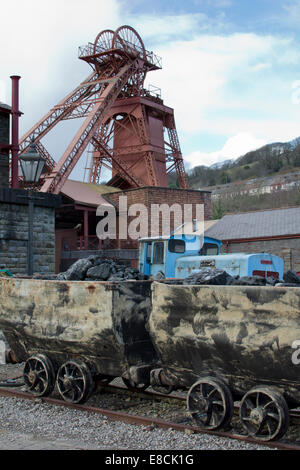 A mining scene. Coal mine winding gear head, train and coal trams Stock Photo