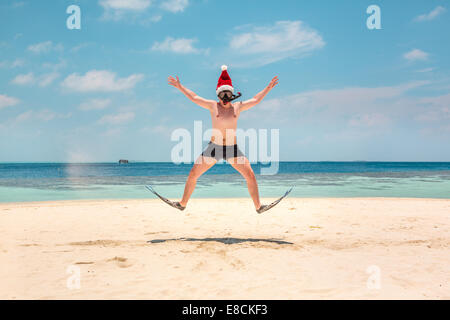 Christmas vacation - man in santa hat on the Maldives tropical beach Stock Photo