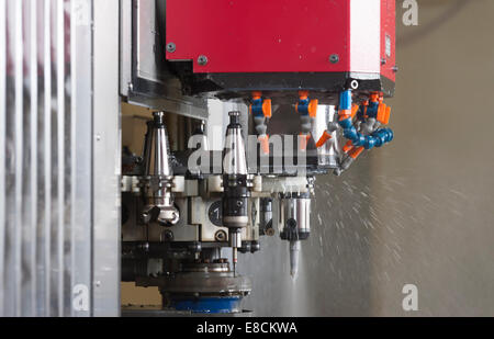 A CNC milling cutter is automatically changing its tooltip during production of a custom aluminum spare part Stock Photo