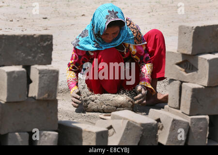 female brickyard worker (20 years) form clay bricks on a field of the Patoki Brick Kiln near Lahore, Pakistan Stock Photo