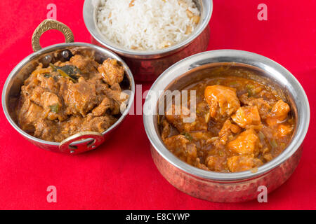 Chili garlic chicken and malabar chicken curry with cashew rice on a red tablecloth. Stock Photo