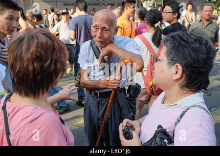 People debate the political situation as pro democracy protests continue in Mongkok, in Hong Kong on 05 October, 2014. Stock Photo