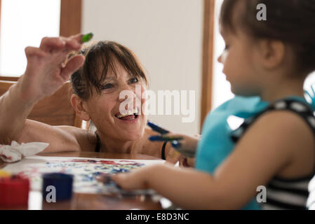 Grandmother finger painting with grandchild Stock Photo