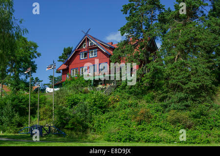 Curonian flags in front of a traditional wooden house, Nida, Klaipėda County, Lithuania Stock Photo