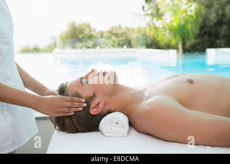 Handsome man receiving head massage at spa center Stock Photo