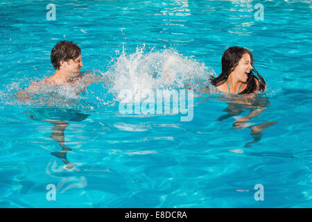Couple playing in swimming pool Stock Photo