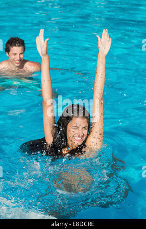 Couple playing in swimming pool Stock Photo