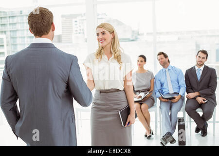 Businesspeople in front of people waiting for interview Stock Photo