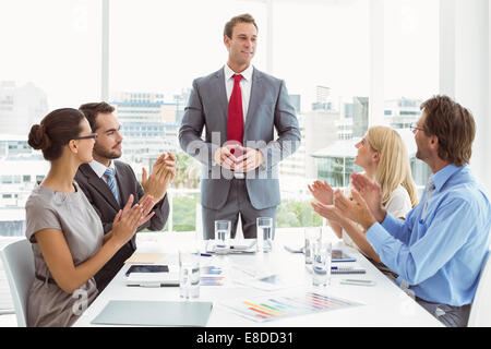 Business people clapping hands in board room meeting Stock Photo