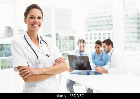 Female doctor with colleagues examining x-ray in medical office Stock Photo