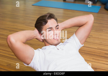 Man doing sit up on exercise ball Stock Photo
