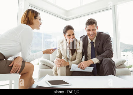 Couple talking to female architect Stock Photo