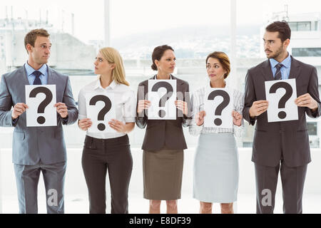 Business people holding question mark signs Stock Photo