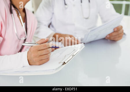 Close up mid section of doctors discussing reports Stock Photo
