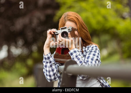 Smiling young woman taking a photo at camera Stock Photo
