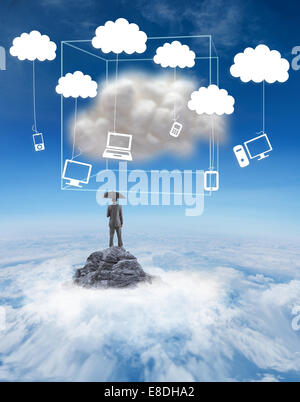 Composite image of businessman standing under umbrella Stock Photo