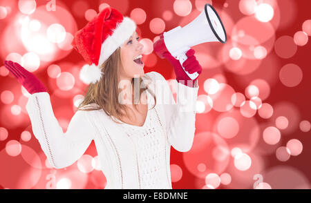 Composite image of festive blonde shouting through megaphone