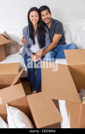 Asian Chinese couple packing or unpacking boxes and moving into a new home. Stock Photo