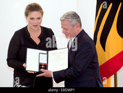 Berlin, Germany. 06th Oct, 2014. Berlin, Germany. 6th October, 2014. German Federal President Joachim Gauck (R) awards Annette Dasch from Frankfurt am Main with an Order of Merit on the occasion of the Day of German Unity in Berlin, Germany, 06 October 2014. According to the President's Office, the singer represents an outstanding cultural ambassador of Germany. © dpa picture alliance/Alamy Live News © dpa/Alamy Live News Stock Photo