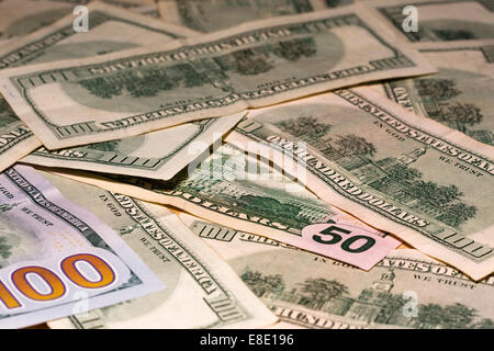 Many Hundred Dollar bills and one Fifty Dollar bill spread on a table top Stock Photo
