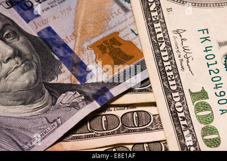 Many Hundred Dollar bills showing micro printing, color reflective gold feather, gold bell and inkwell and 3D security ribbon Stock Photo