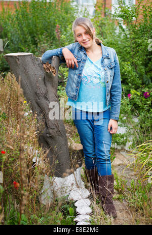 A teenage girl dressed in denim jeans and jacket Stock Photo