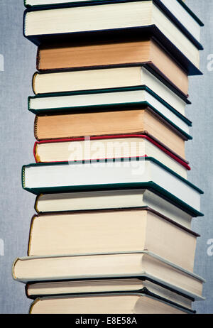 High stack of books over a gray background Stock Photo