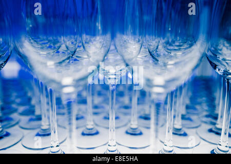Many Empty Wineglasses Upside Down on a White reflective Table Stock Photo