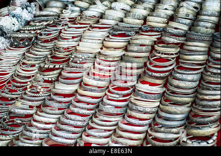 Lot of cheap souvenir bangles at asian market place. Laos Stock Photo