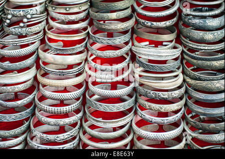 Lot of cheap souvenir bangles at asian market place. Laos Stock Photo