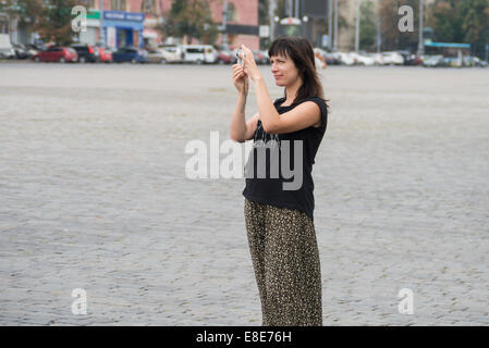 a portrait of a nice girl shooting photo in a square Stock Photo