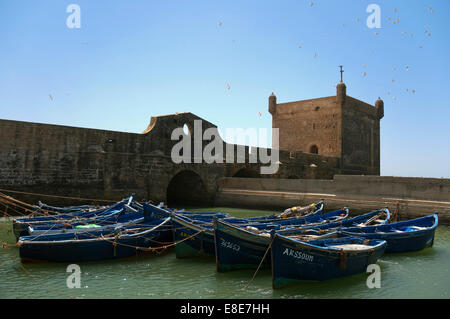 Horizontal view of the fortress in Essaouira with traditional fishing boats on a sunny day. Stock Photo