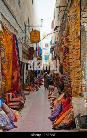 Vertical view down a colourful alleyway selling carpets and rugs in Essaouira Stock Photo