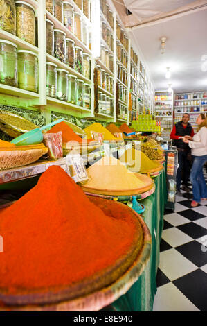 Vertical portrait of a tourist buying spices in a shop in the souks of Marrakech. Stock Photo