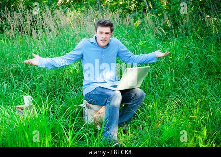 incomprehension of a man lost in nature with technology Stock Photo