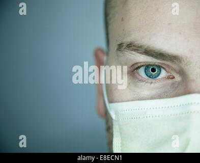 Young doctor with bald head wearing a mask and on a gray background (in studio) Stock Photo