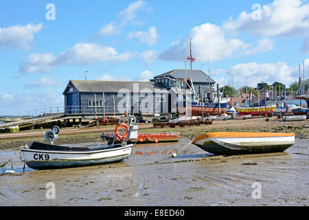 Mersea island lifeboat station building and boat yards along the waterfront with mud beach at low tide Stock Photo
