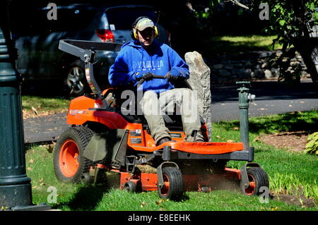 Grafton, Vermont:  Man riding a motorised lawn mower working on a lawn Stock Photo
