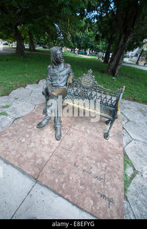 A bronze statue of Beatle John Lennon sitting on a bench in John Lennon park (formerly known as Parque Menocal) in Havana Cuba Stock Photo