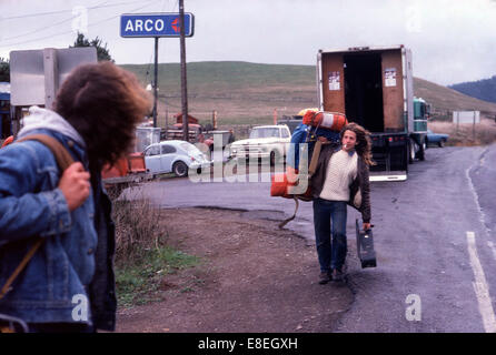 Young men teenager hippies hitchhiking (hitching a lift) past an ARCO gas station on Highway 101 California in USA 1977    KATHY DEWITT Stock Photo
