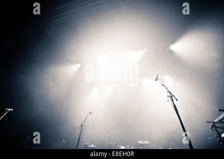 Empty illuminated stage with drumkit, guitar and microphones Stock Photo