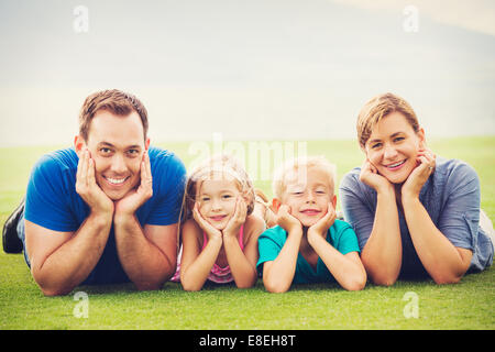Portrait of Happy Family of Four Outside. Parents and Two Young Children Stock Photo