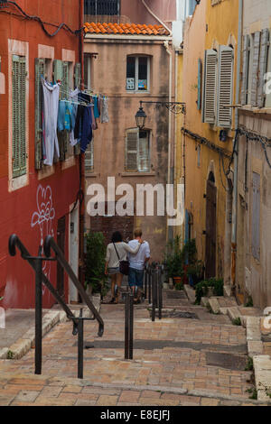 Young couple walking down stairs in the Panier district of old Marseille, France. Stock Photo