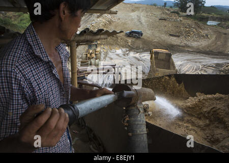 Laiza, Kachin, Myanmar. 8th July, 2014. A Chinese gold miner sprays the soil with a high-powered water jet, separating gold from soil at a gold mining site. (Credit Image: © Taylor Weidman/zReportage.com via ZUMA Press) Stock Photo