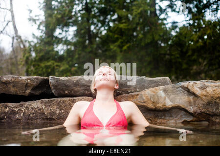 Young Woman Relaxing in a Outdoor Nordic Spa, in the forest. Stock Photo